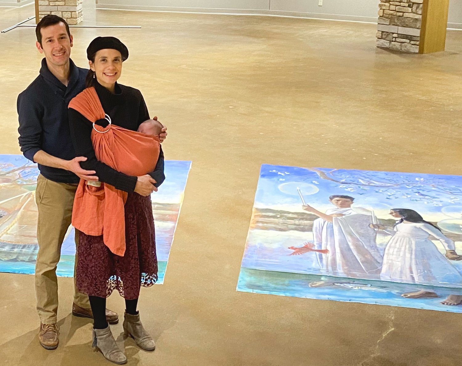 Andrew and Gwyneth Thompson-Briggs hold their son near the soon-to-be-installed murals Mrs. Thompson-Briggs painted for the new baptistery of the Cathedral of St. Joseph in Jefferson City, which is undergoing substantial renovation, expansion and renewal.